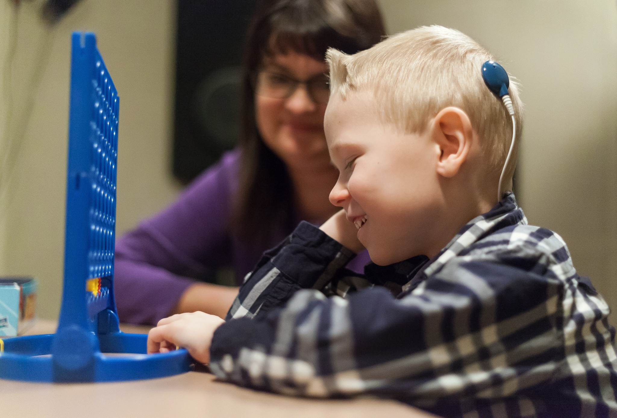 Audiology-KS Child audiology patient playing connect four with Glenrose staff.